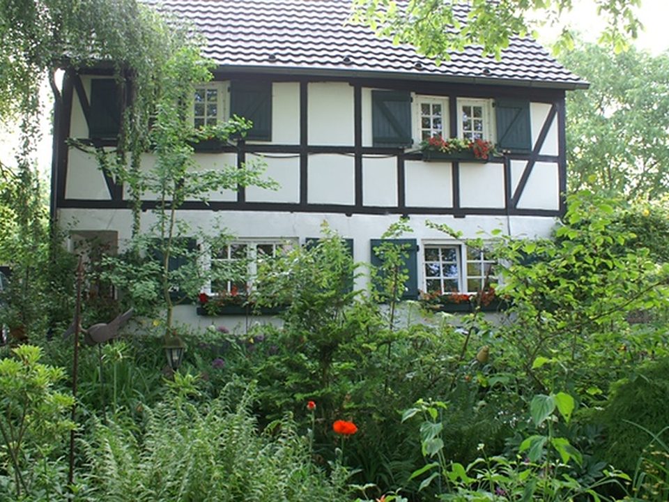 Restauriertes Fachwerkhaus mit blühendem Garten