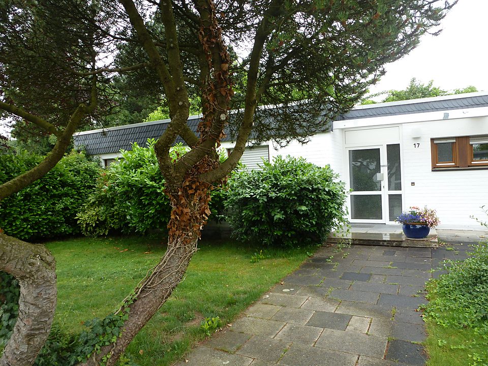 Weißer Bungalow mit großem Garten und altem Baumbestand